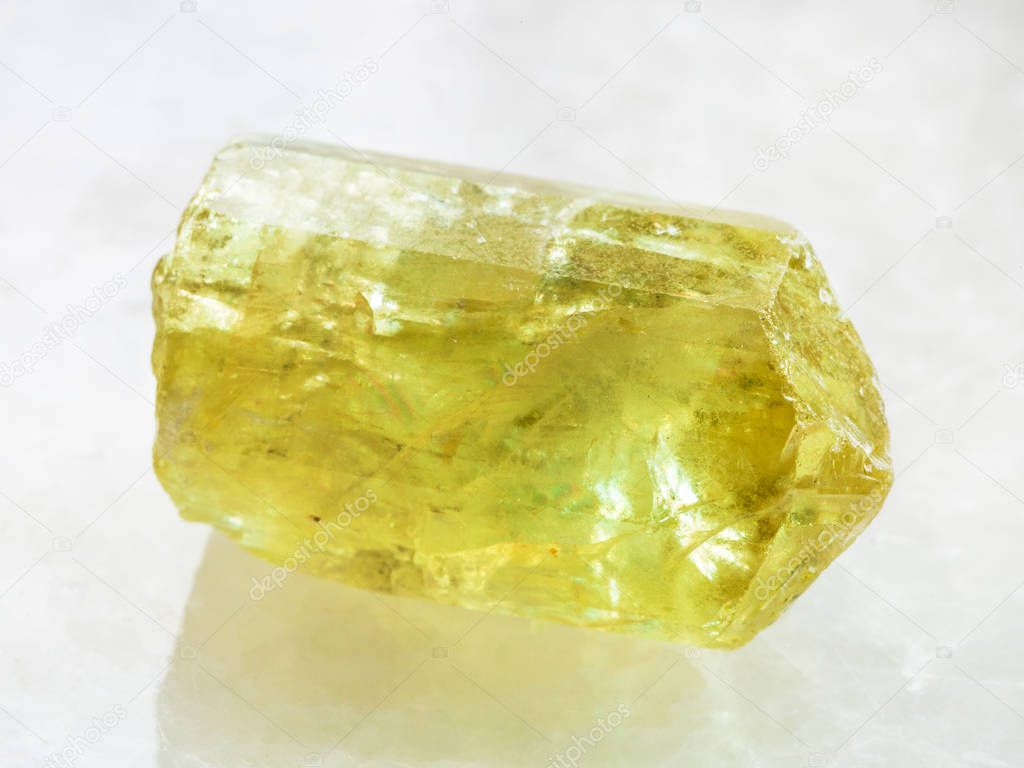 raw crystal of yellow Apatite gemstone on white