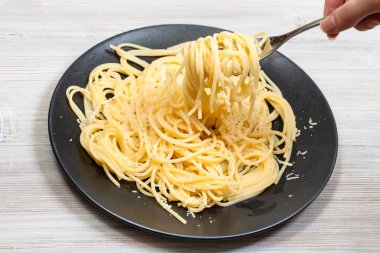 Siyah tabağın üzerinde kıvrımlı spagetti