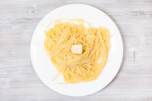 Vista de macarrão com manteiga na placa branca em cinza — Fotografia de Stock