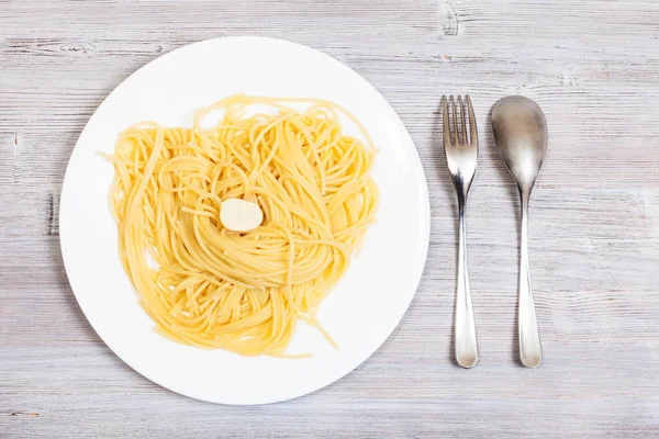 Pasta med smör på tallrik och gaffel med sked — Stockfoto