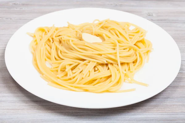 Macarrão com manteiga na placa branca na mesa cinza — Fotografia de Stock