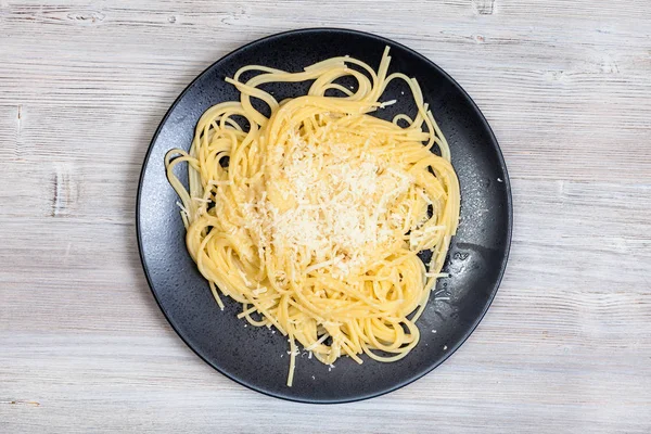 Pasta with butter and cheese on gray table — Stock Photo, Image