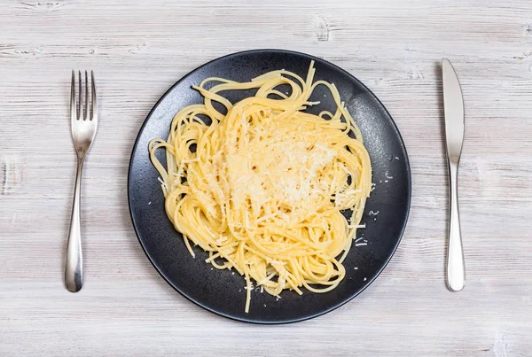 Pasta con mantequilla y queso y tenedor con cuchillo — Foto de Stock