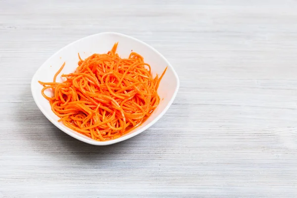 Κοργιο-σαράμ πικάντικα καρότα σε μπωλ σε γκρι τραπέζι — Φωτογραφία Αρχείου