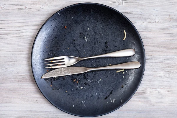 Faca e garfo mentira paralela na placa na mesa cinza — Fotografia de Stock