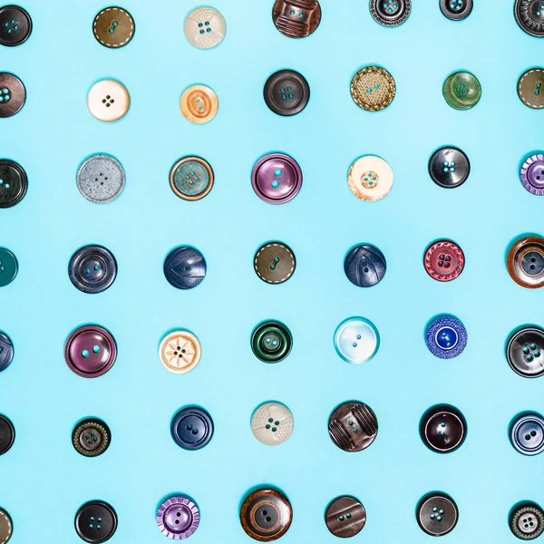 Muitos botões diferentes dispostos no fundo azul — Fotografia de Stock