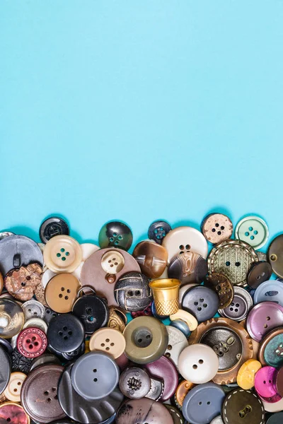 Pile of various buttons on blue with copyspace — Stock Photo, Image