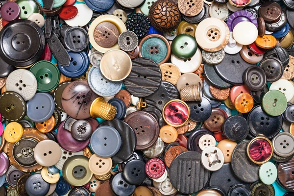 Heap of many different buttons close up on blue — Stock Photo, Image