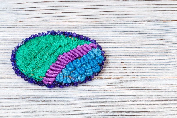 Oval brooch embroidered by silk threads on gray — Stock Photo, Image