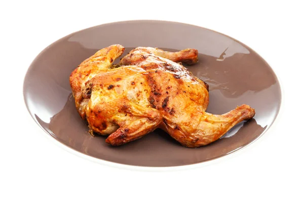 Жареная целая сплющенная курица на коричневой тарелке — стоковое фото