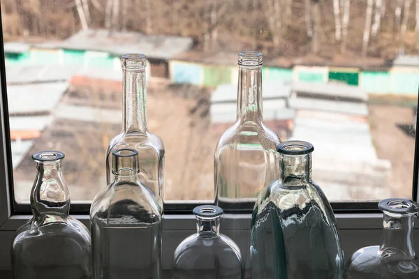 Wiele Pustych Butelek Parapecie Widok Dziedziniec Przez Okno Domu Słoneczny — Zdjęcie stockowe