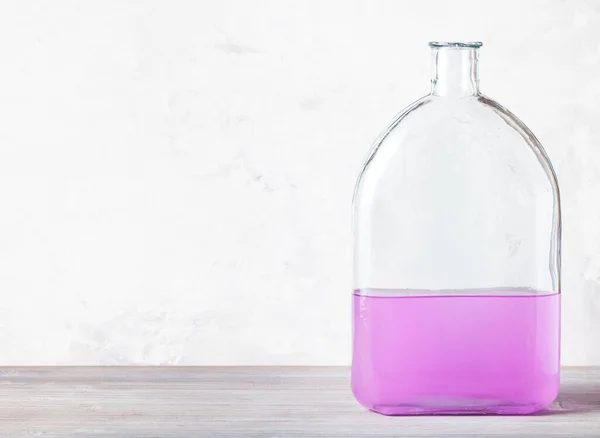 Glazen Kolf Met Roze Aquareloplossing Grijze Houten Plaat Bij Grijze — Stockfoto