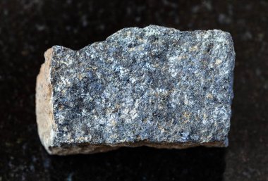 Jeolojik koleksiyondaki doğal mineral örneğinin yakın çekimi - Güney Karelia, Rusya 'dan siyah granit zemin üzerinde cilalanmamış çinko cevheri (Sphalerite) taşı