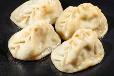 Siyah tabakta Manti 'nin (Türk mutfağındaki mantı türü) bir bölümü