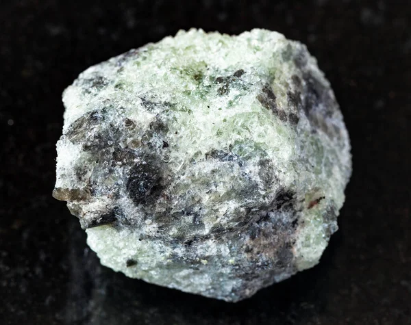 地質学的コレクションからの天然鉱物のサンプルの閉鎖 研磨されていない石灰岩ロシア コラ半島のKhibini Kolaから黒御影石の背景にあるアパタイト岩 — ストック写真