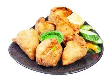 Hint mutfağı - beyaz arka planda izole edilmiş siyah tabakta bir sürü samosa (kızarmış baharatlı hamur tatlısı)