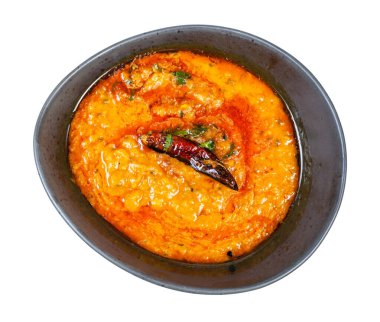 Hint mutfağı - beyaz arka planda izole edilmiş siyah kasede sarı Dal Tadka 'nın (mercimekli baharatlı ve kremalı sebze çorbası) üst görüntüsü