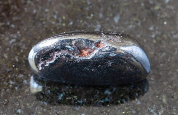 地質学的コレクションからの天然鉱物のサンプルの閉鎖 黒い花崗岩の背景にヘマタイト岩の腫瘍 — ストック写真