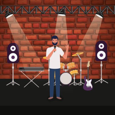 Adam konser sahnesinde mikrofonla şarkı söylüyor.