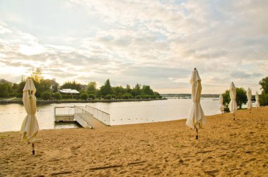 bir su birikintisi yanındaki Plajda şemsiye 
