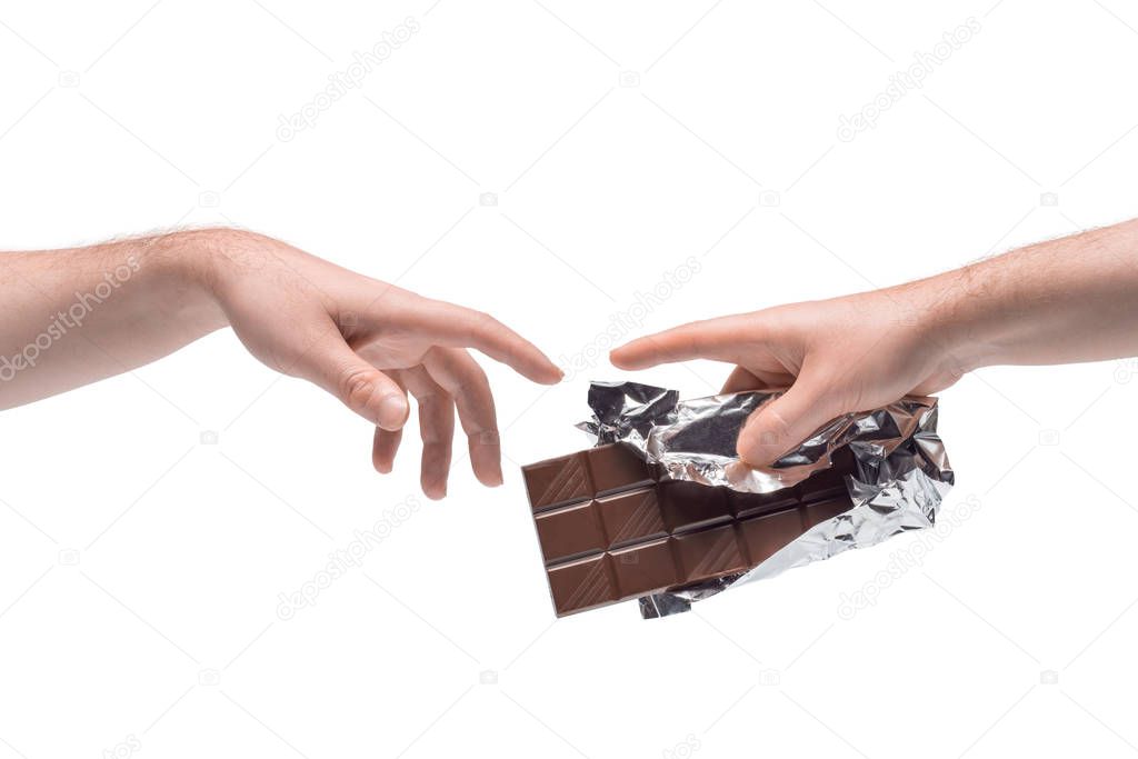 Two male hands passing one another chocolate bar in foil on white background