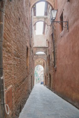 Siena is a charming narrow street in the medieval town of Tuscany, Italy.