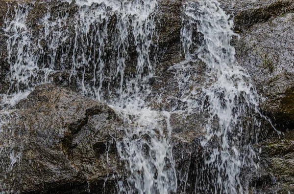 Água escorrega para baixo da rocha — Fotografia de Stock