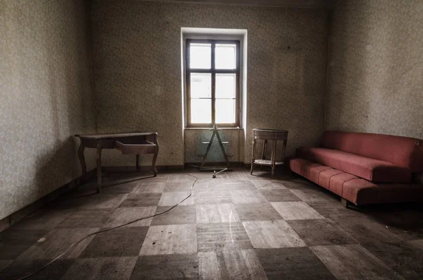 Abandoned room with red couch — Stock Photo, Image