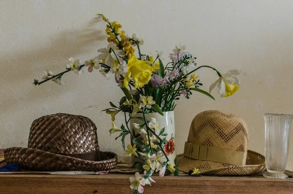 Hats and flowers in old house — Stock Photo, Image