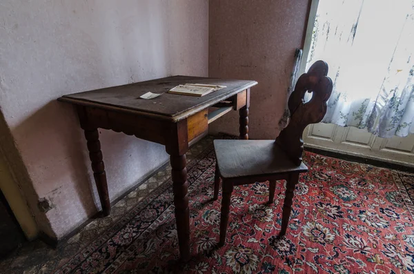 Стол с книгой и креслом в комнате — стоковое фото