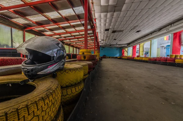 Casco y neumáticos en pista de kart — Foto de Stock