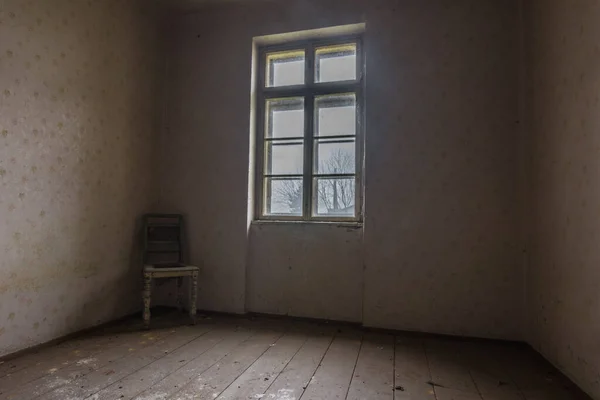 Темная комната с креслом в углу — стоковое фото