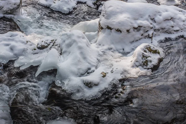 Strömendes Wasser in einem Bach mit Schnee — Stockfoto