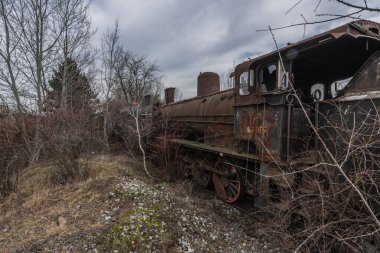 Yan tarafta paslı bir tren var.