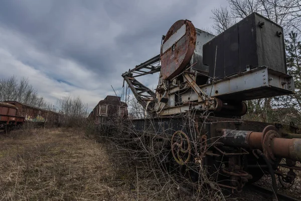 Decayed train with crane in nature — 스톡 사진