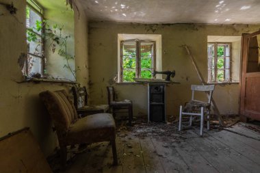 Pencerede koltuk ve dikiş makinesi olan bir oda