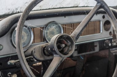 Koridordaki eski bir arabanın kontrol paneli ve direksiyonu.