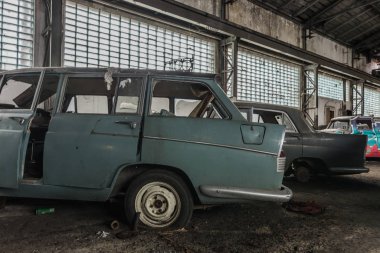 Oto tamirhanesinde camları olan eski arabalar.