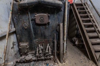 Bir evin mahzeninde büyük paslı bir fırın.