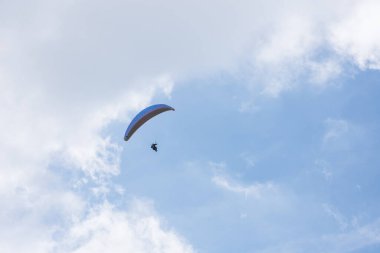 Gökyüzünde süzülen paraglider Dağlarda bulutlar