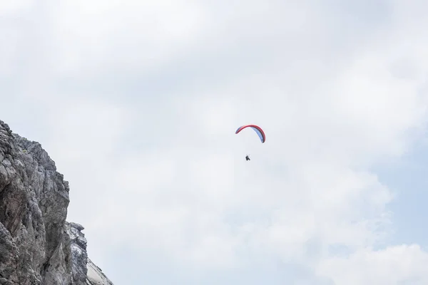 在山上的岩石表面上漂浮着滑翔伞 — 图库照片