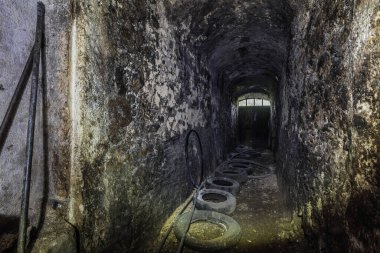 Eski bir hanın mahzeninde karanlık bir oda.