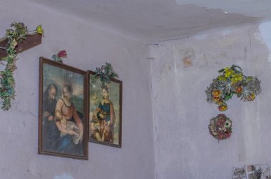 Terk edilmiş bir evin duvarında iki resim.