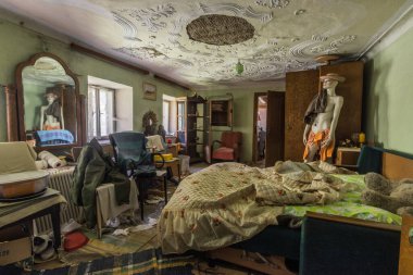 Terk edilmiş bir evdeki aynada yansıması olan manken.