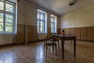 Eski bir manastırın odasındaki bir masada oturan küçük bebek.