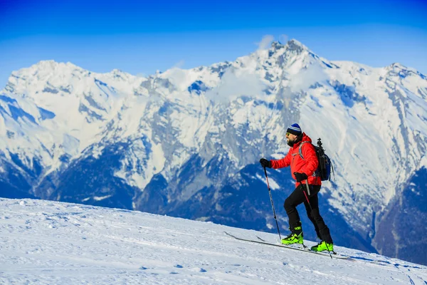 Esquí de travesía hombre llegar a la cima al amanecer en los Alpes suizos . —  Fotos de Stock