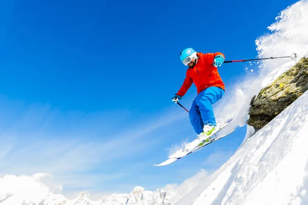 Человек катается на лыжах в свежем снегу в итальянских Альпах, захвачен прыжок — стоковое фото