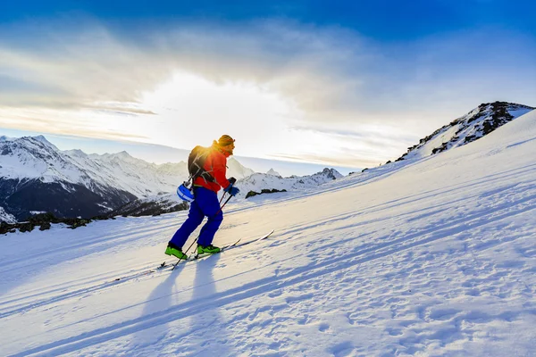 Toerskiën mens bereiken van de top bij zonsopgang in Zwitserse Alpen. — Stockfoto