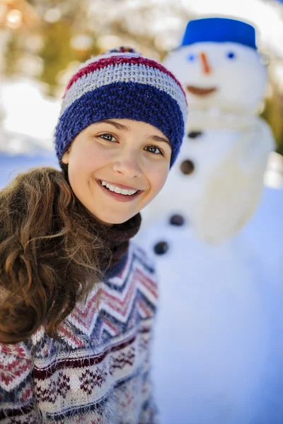 快乐微笑的少女，玩一个雪人在白雪皑皑的胜利 — 图库照片