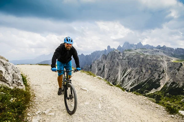 View of cyclist riding mountain bike on trail in Dolomites, Tre C — стоковое фото